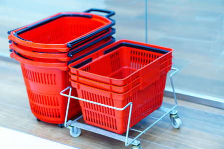Store baskets of different shapes of red color stand on the floor