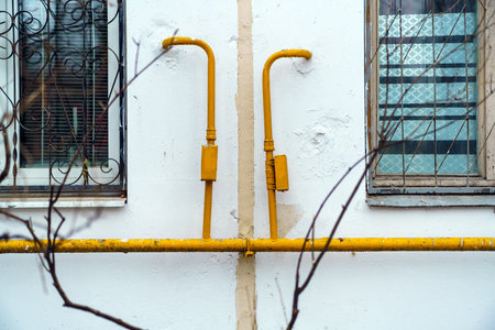Gas pipe of yellow color from which there are two outlets to different apartments