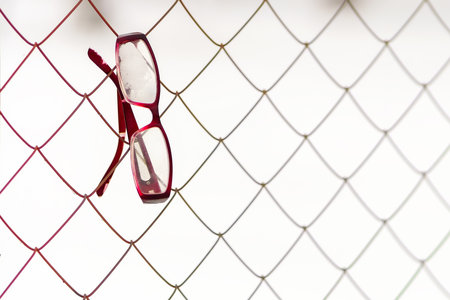 Glasses are lost and hang on the wire in winter covered with snowの写真素材