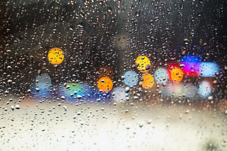 Water droplets on the glass behind framed colored spotsの写真素材