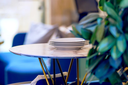 Round table with a stack of clean plates in the restaurant for servingの写真素材