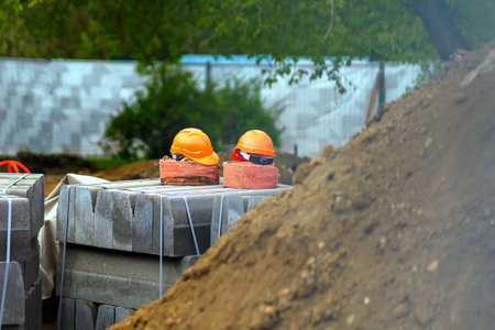 Workers' orange helmets lie on rolled cables during rest