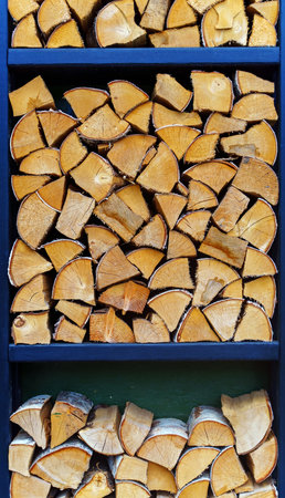 Fresh birch firewood is stacked in special rectangular storage compartmentsの写真素材