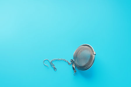 Closed metal tea strainer on bright blue backgroundの写真素材
