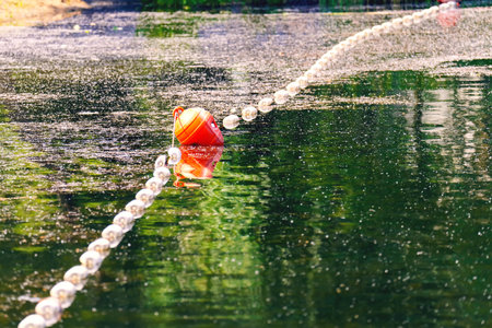 Barrage buoys on an abandoned green lake