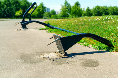 A broken rack for attaching bicycles and scooters lies on the sidewalkの写真素材