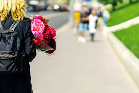 A girl with a bouquet in her hands meets peopleの写真素材