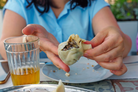 A woman shows the filling of khinkali with mushroomsの写真素材