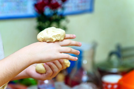 Child holding a piece of raw dough in his hand