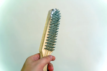Wooden brush with metal pile on wall backgroundの写真素材