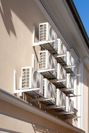 Several rows of identical air conditioners on the wall