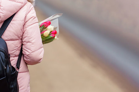 Person carrying a bouquet of tulips in the crook of their armの写真素材