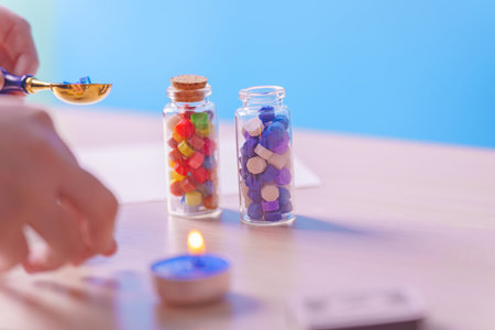 Two small bottles with colorful wax, a candle, and a wax seal stickの写真素材