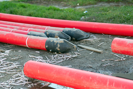 large red plastic tubes equipped with specialized black clamps, designed for seamless attachment to equipment for efficient transportation and maneuveringの写真素材