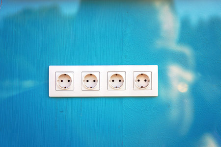 quad electric socket set against a soothing lavender-blue wall, symbolizing connectivity and modern...