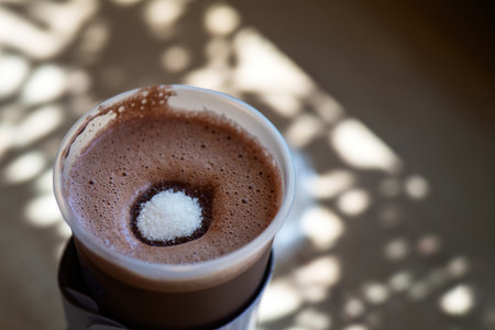 sugar mound dissolves in a steaming glass of cocoa, symbolizing the fusion of sweet moments and warmth, evoking a cozy atmosphere and nostalgic memoriesの写真素材