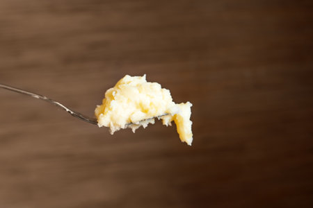 Fork resting atop a mound of creamy mashed potatoes, transcending mere dining. It symbolizes nourishment, comfort, and the simple joys of home-cooked mealsの写真素材