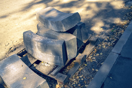 Curved concrete curb stones gracefully delineate a turning path, blending functionality with aesthetic appeal. Their rounded shape enhances urban landscapes while guiding traffic flowの写真素材