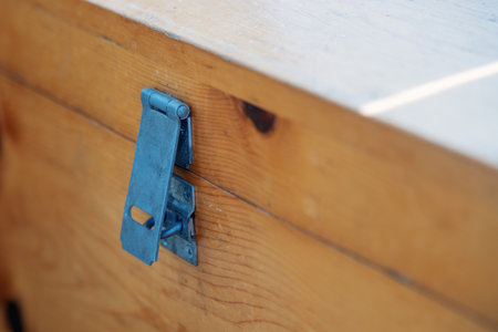 aged metal hasps for a padlock, affixed to a weathered wooden chest, symbolizing secrets buried in time and the allure of forgotten treasuresの写真素材