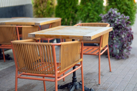outdoor restaurant furniture casts soft shadows on the sidewalk, creating a welcoming atmosphere for diners. The scene invites relaxation and enjoyment of culinary delights al frescoの写真素材