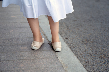 girl legs with a distinctive foot misalignment, set against the stark backdrop of asphalt, symbolizing uniqueness and individualityの写真素材