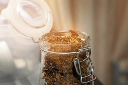 Lactation tea for nursing mothers in a glass jar with a hinged lid, natural herbal blend to support breastfeedingの写真素材