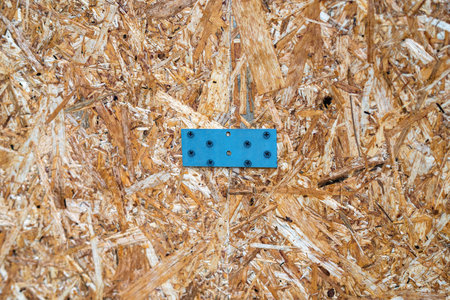 Two chipboard (DSP) panels joined with a metal bracket and screws, showing sturdy construction or furniture assembly.の写真素材