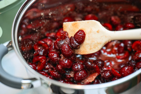 Cooking cranberry sauce in a saucepan, close-upの写真素材