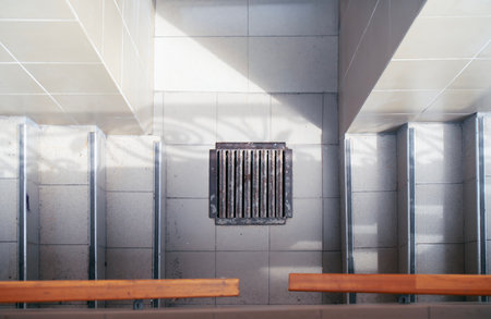 Metal storm drain grate positioned between two concrete staircases leading to a basement, showcasing...