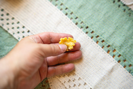 Man's hand holding a piece of chewed beeswax, natural alternative to chewing gum with organic...