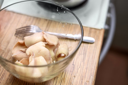 Cooked squid bodies in a glass bowl, freshly prepared seafood ready for serving or further cooking.