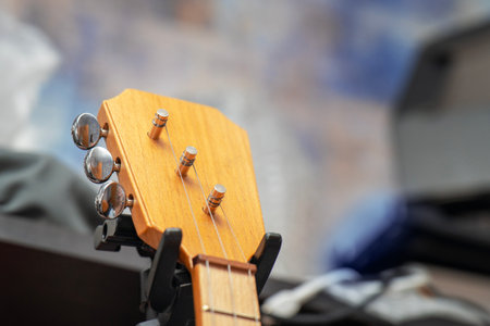A balalaika held on cabinet by special plastic grip securing its neck.