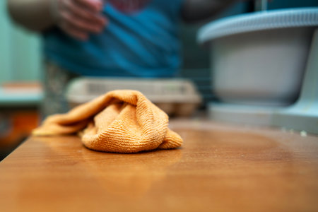 Microfiber cloth lying on kitchen table after wiping flour during baking cleanup.の写真素材