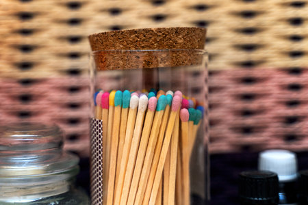 Large wooden matches with colored heads standing in glass jar on shelf.の写真素材