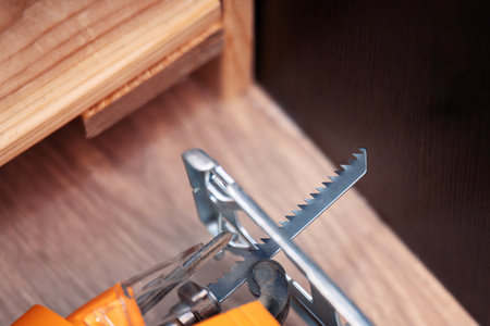 Jigsaw with wood blade lying on worktop during home repair or DIY project.の写真素材