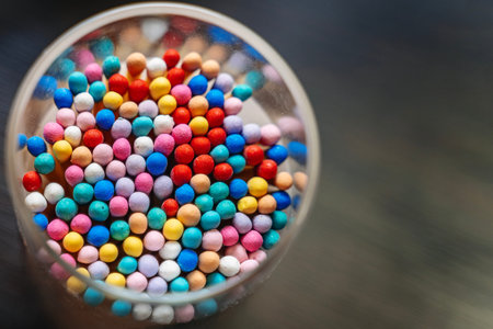 Top view of match heads in various colors standing in a glass. Colorful utility and fire-starting...