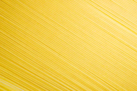 Background of yellow raw uncooked spaghettiの写真素材