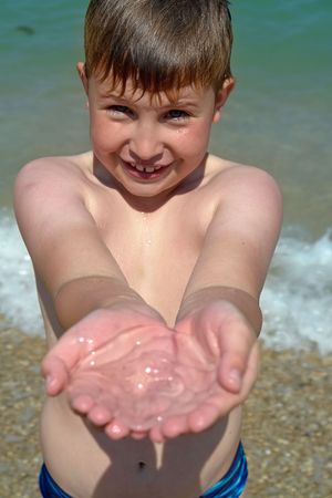 A little boy with a jellyfish on the beachの写真素材