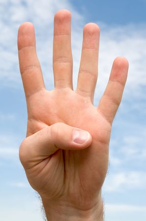 four. hand gesture with blue sky at backgroundの写真素材