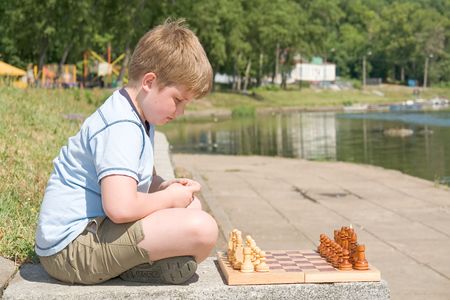 little boy chess with river at backgroundの写真素材