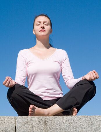 Meditation. The girl meditates with sky at background.の写真素材