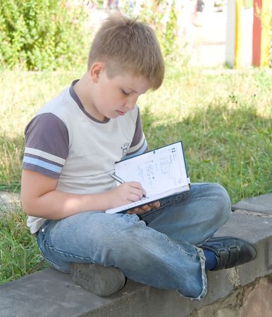 The little boy writes to writing-booksの写真素材