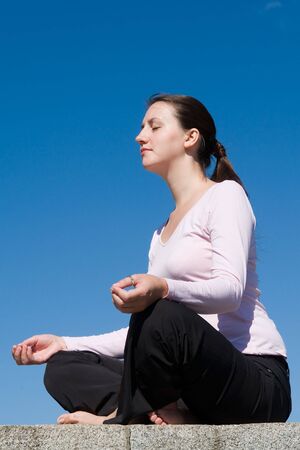 Meditation. The girl meditates with sky at background.の写真素材