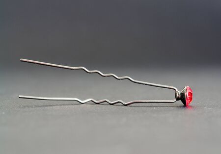 Hairpin with a ruby on a grey backgroundの写真素材
