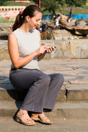 girl with mobile phone In a summer parkの写真素材
