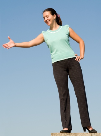 beautiful woman greeting on a blue skyの写真素材