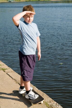 boy on a skateboard with river at backgroundの写真素材