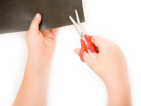 Children's hands with scissors cut a paperの写真素材