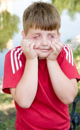I can make this face...  Young boy pulling a scary faceの写真素材