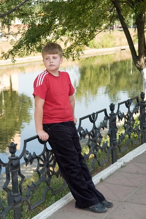 little boy. sad eyes. sad face. portrait with river at backgroundの写真素材